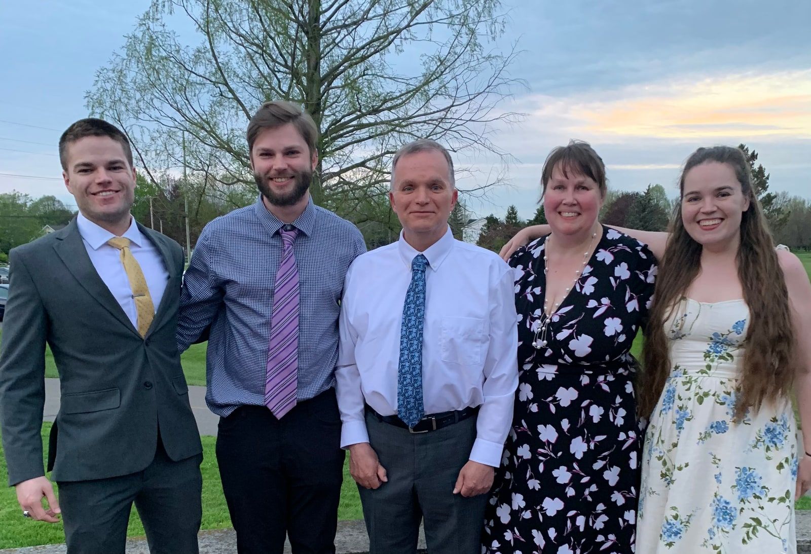 JohnLuc standing with his family outdoors.